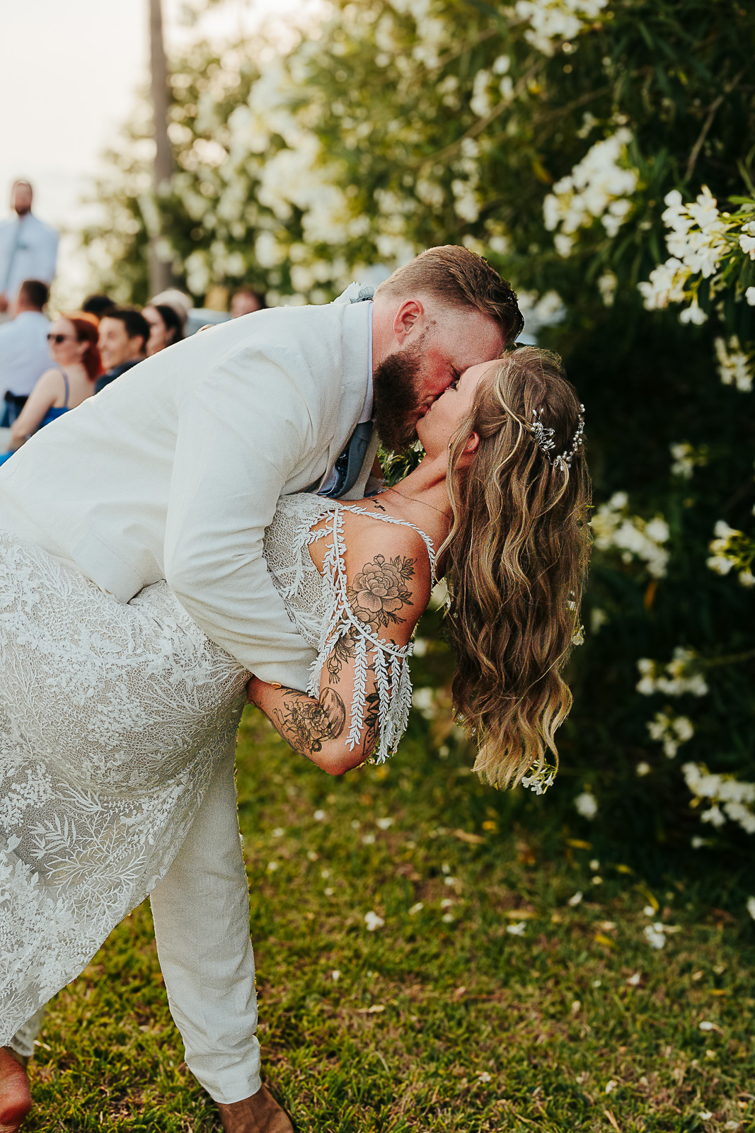 Bride and groom share a dip kiss surrounded by golden hour light — Texas Hill Country wedding